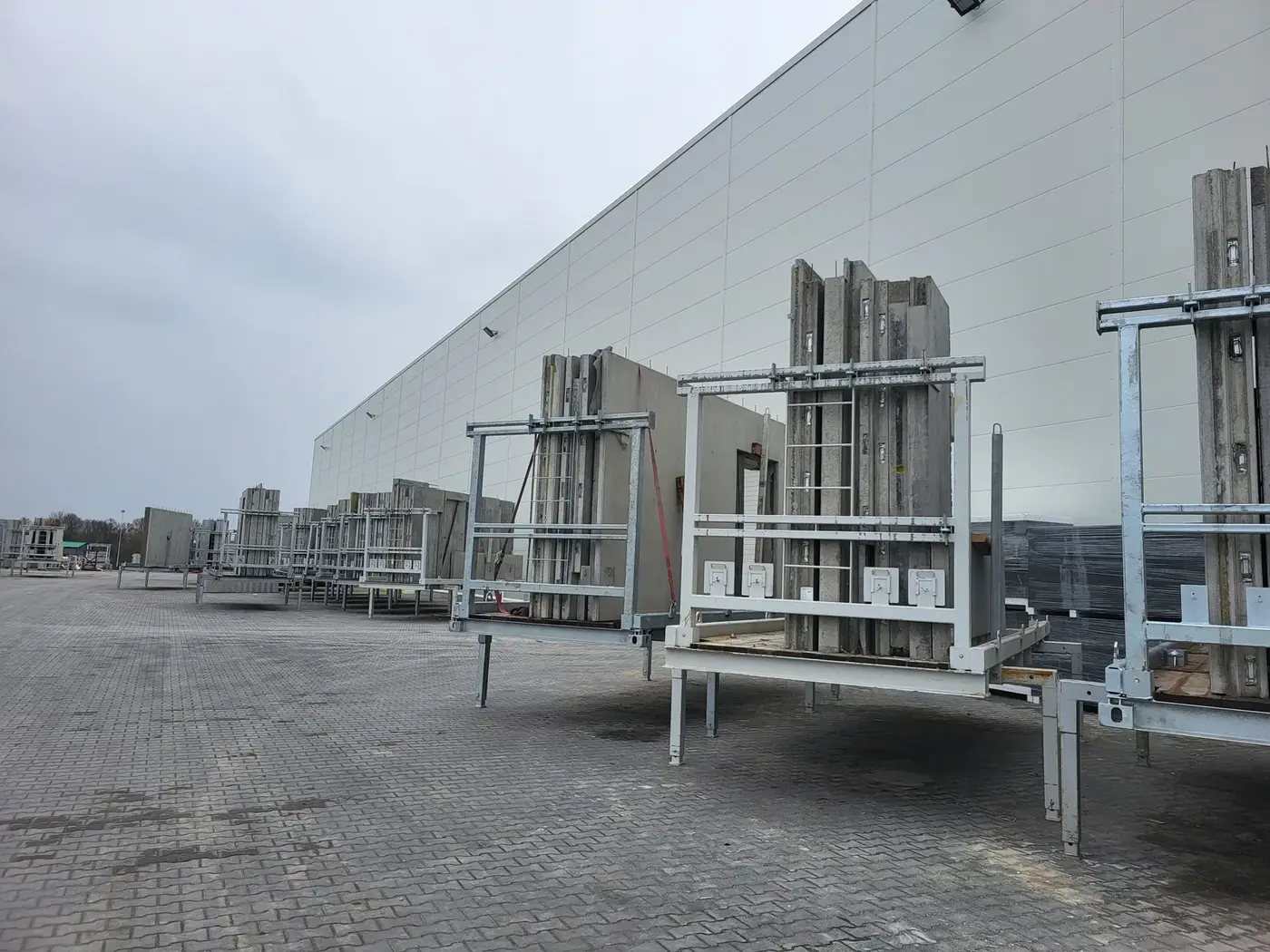 Gotowe ściany prefabrykowane na stojakach transportowych, plac składowy zakładu Formee